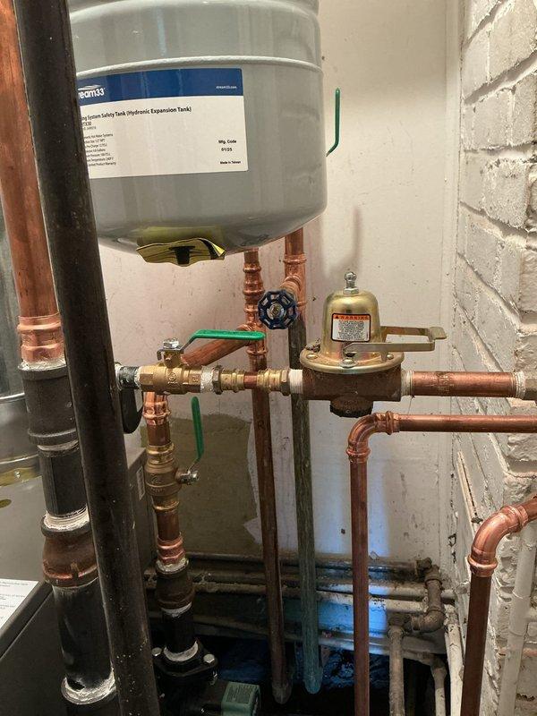 Installed Lennox 120,000 BTU floor mount boiler system in basement utility area. Installation included complete setup of boiler unit with associated copper supply and return piping, expansion tank mounting, pressure relief components, and metallic vent pipe system with proper exhaust configuration. All connections secured with appropriate brass fittings, shutoff valves installed for system isolation, and pressure regulation devices integrated per manufacturer specifications. System tested and confirmed operational upon completion.