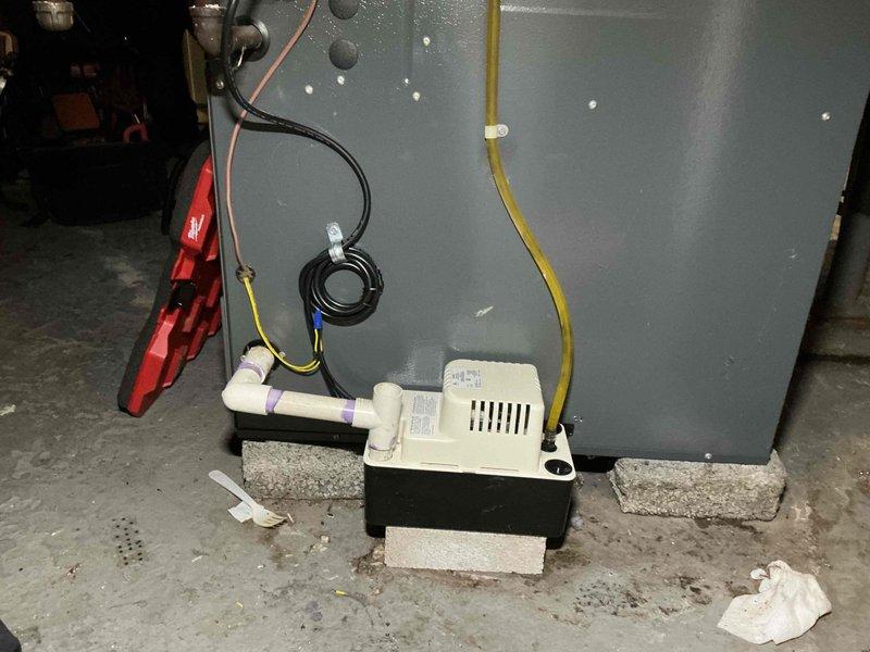 Responded to no heat call on 7-year-old gas furnace. Upon arrival, diagnosed issue related to condensate pump system. Inspected condensate pump assembly and drainage lines, finding obstruction preventing proper water removal which had triggered safety switch and shut down furnace operation. Cleared blockage from condensate pump, verified proper pump function, and tested drainage flow through yellow discharge line and white PVC piping. Reset safety switch, restored power to furnace, and confirmed unit fired properly with normal heat operation. System returned to full functionality with all safety devices operating as designed.