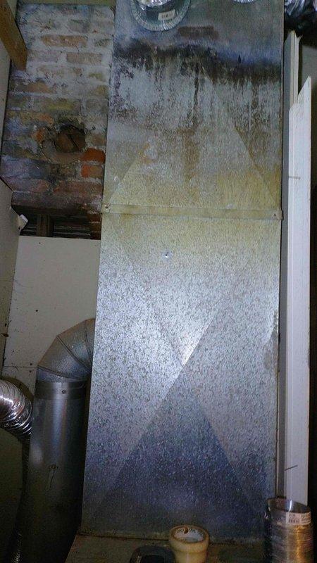 Responded to service call regarding carbon dioxide infiltration into living space. Upon inspection, identified compromised ductwork system with significant moisture damage and deterioration to air handler unit and surrounding mechanical room infrastructure. Documented extensive water staining, corrosion, and structural degradation on vertical ductwork panel and floor surfaces indicating long-term moisture exposure. Installed new duct run to properly vent combustion gases and prevent CO2 from entering occupied areas of home. Verified proper venting configuration to ensure safe operation of heating system and eliminate hazardous gas infiltration into living spaces.