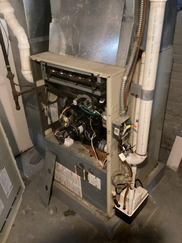 Conducted comprehensive assessment of existing residential gas furnace system for replacement estimate. Inspected current unit with access panel removed, evaluating internal components including blower motor assembly, burner compartment, electrical connections, and wiring harness. Documented existing ductwork configuration, including main supply plenum and distribution system. Assessed auxiliary components such as PVC condensate drain lines, gas supply piping, and electrical conduit routing. Photographed equipment installation in basement utility area to determine spatial requirements and identify any clearance considerations for new unit installation. Provided detailed replacement estimate based on current system configuration and customer heating needs.