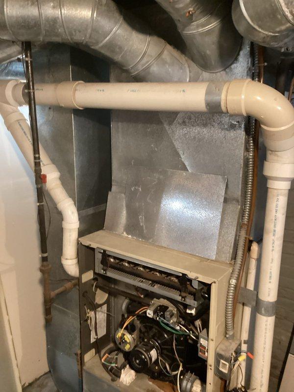 Conducted comprehensive assessment of existing residential gas furnace system for replacement estimate. Inspected current unit with access panel removed, evaluating internal components including blower motor assembly, burner compartment, electrical connections, and wiring harness. Documented existing ductwork configuration, including main supply plenum and distribution system. Assessed auxiliary components such as PVC condensate drain lines, gas supply piping, and electrical conduit routing. Photographed equipment installation in basement utility area to determine spatial requirements and identify any clearance considerations for new unit installation. Provided detailed replacement estimate based on current system configuration and customer heating needs.