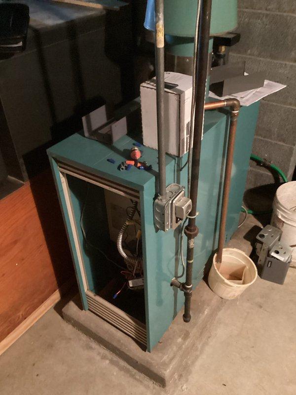 Completed comprehensive assessment of existing boiler system in basement mechanical room for equipment replacement quote. Documented current turquoise-colored hydronic heating unit with copper piping distribution, associated controls, and ancillary components including proximity to domestic water heater. Photographed installation conditions, clearances, existing piping configurations, and mechanical room layout to develop accurate replacement specifications and scope of work for customer approval.