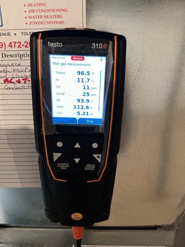 Responded to emergency call for furnace leaking water following recent repair on seventeen-year-old unit. Upon arrival, performed combustion analysis using Testo 310 II analyzer, which revealed acceptable readings: stack temperature 96.5°F, oxygen 11.7%, carbon monoxide 11 ppm, CO air-free 25 ppm, efficiency 93.9%, excess air 112.6%, and CO2 5.21%. Inspected internal components and identified significant dust and debris accumulation throughout air handler and ductwork system. Located source of water leak in condensate drain system area with visible moisture intrusion and opening in metal housing. Documented equipment condition with photographs showing combustion analysis results and internal component deterioration. Advised customer of findings and recommended thorough system cleaning and condensate drain line servicing to prevent future water damage.