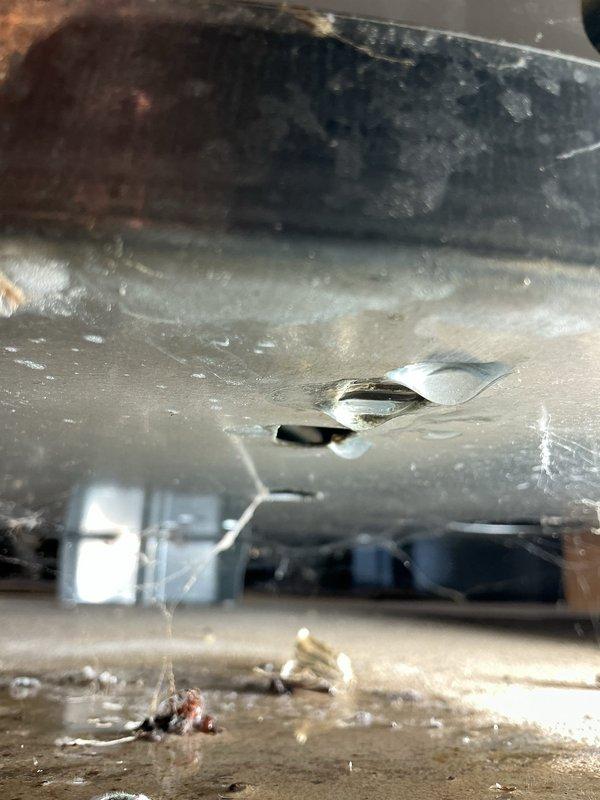 Responded to emergency call for furnace leaking water following recent repair on seventeen-year-old unit. Upon arrival, performed combustion analysis using Testo 310 II analyzer, which revealed acceptable readings: stack temperature 96.5°F, oxygen 11.7%, carbon monoxide 11 ppm, CO air-free 25 ppm, efficiency 93.9%, excess air 112.6%, and CO2 5.21%. Inspected internal components and identified significant dust and debris accumulation throughout air handler and ductwork system. Located source of water leak in condensate drain system area with visible moisture intrusion and opening in metal housing. Documented equipment condition with photographs showing combustion analysis results and internal component deterioration. Advised customer of findings and recommended thorough system cleaning and condensate drain line servicing to prevent future water damage.