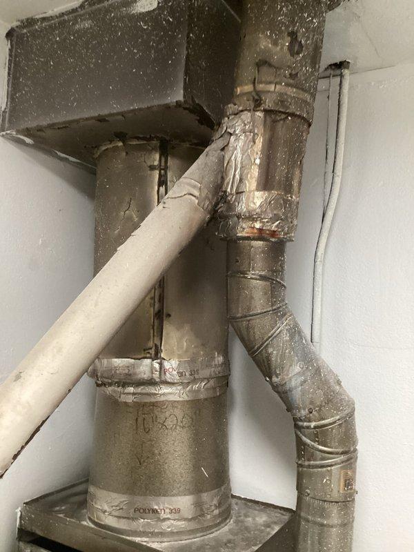 Completed comprehensive assessment of existing HVAC system for furnace replacement estimate. Inspected aging furnace unit showing significant dust accumulation and wear, along with associated ductwork connections including metal plenum assemblies and flexible insulation-wrapped ducts. Documented current equipment condition, ductwork configuration, and mechanical room layout to provide accurate replacement specifications and installation requirements.