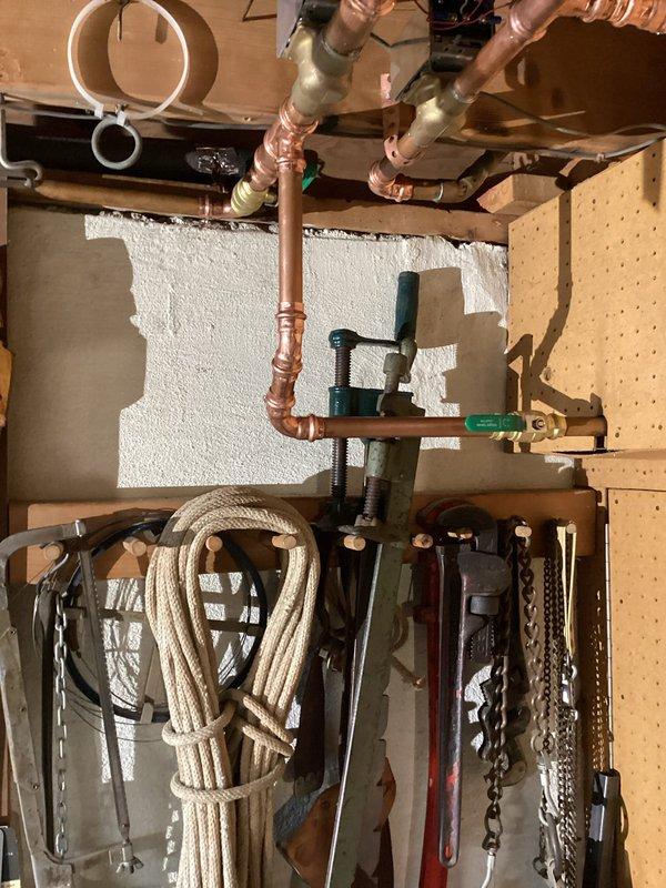 Completed residential boiler installation in basement mechanical room. New boiler unit was mounted on concrete pad with proper copper piping connections, green-handled isolation valves, and distribution lines routed to existing heating zones. All soldered joints were completed to code specifications, pressure tested, and system was commissioned for operational use alongside existing water heater.