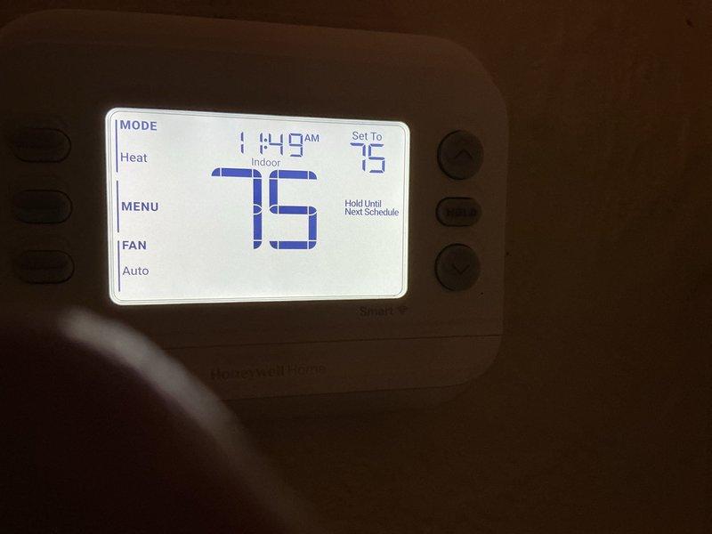 Responded to a warranty callback for a heating system that would not cycle off and continued delivering hot air to the home. Inspected the Honeywell Home thermostat, which was in Heat mode with the setpoint at 75°F and the indoor temperature reading 75°F, and verified operation. Measured differential pressure of 3.47 inH2O with a Testo 510i manometer to evaluate the furnace's pressure and airflow performance.