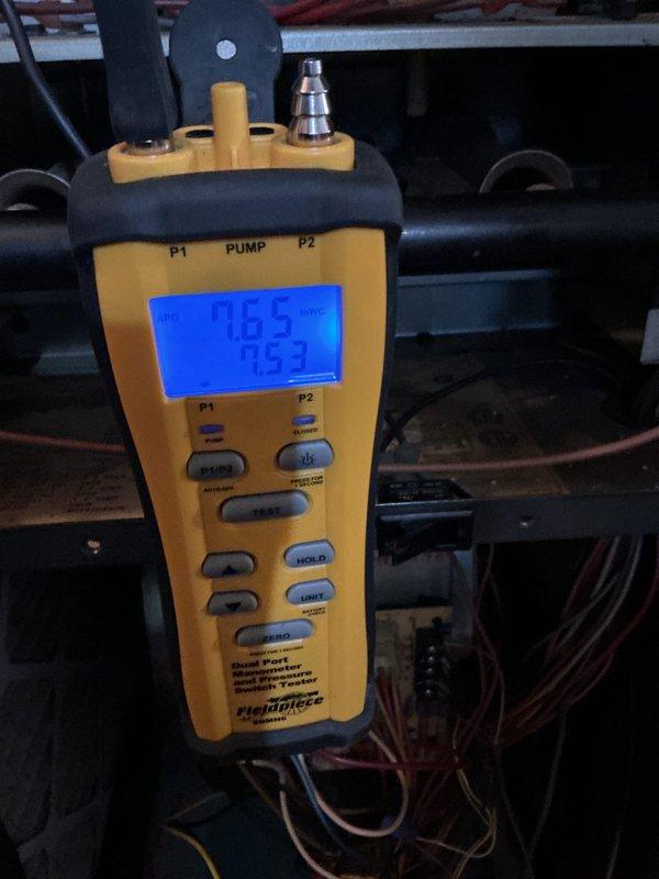 Performed annual maintenance on a 7-year-old gas furnace, including inspection of the burner assembly and flame sensor, where light corrosion and residue were noted on the sensor fitting and enclosure base. Verified draft/pressure switch operation and system pressure readings using a dual-port digital manometer, with both ports reading approximately 7.5 inWC, and checked control board wiring and connections for proper condition.