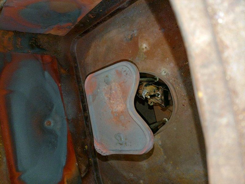 Performed a routine furnace tune-up and inspected the combustion chamber, pilot assembly, and burner compartment. Verified the pilot flame was lit and burning blue, and documented significant corrosion and heat-related discoloration on the interior combustion chamber surfaces and cover plate. System was operating properly at time of service; recommend monitoring the corrosion and evaluating the unit for potential replacement given its unknown age and condition.