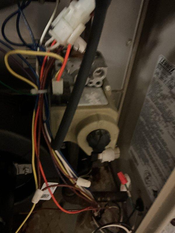 Performed a seasonal tune-up on a 5-year-old gas furnace, verifying the unit was level and inspecting the condensate PVC drain line and fittings. Inspected the gas valve assembly and low-voltage/line-voltage wiring connections, noting minor surface corrosion beneath the gas valve. Confirmed secure wire routing and documented equipment data plate information for service records.