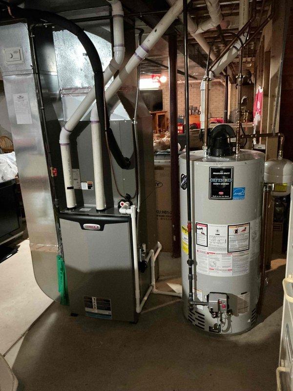 Performed annual preventive maintenance on a 3–4 year old Lennox gas furnace, inspecting the cabinet, plenum, ductwork connections, PVC intake/exhaust venting, and condensate drain line and trap, with no visible rust, cracks, or damage noted. System was found operating properly with no issues reported, and the attached Carrier humidifier and adjacent water heater area were also observed in good condition.