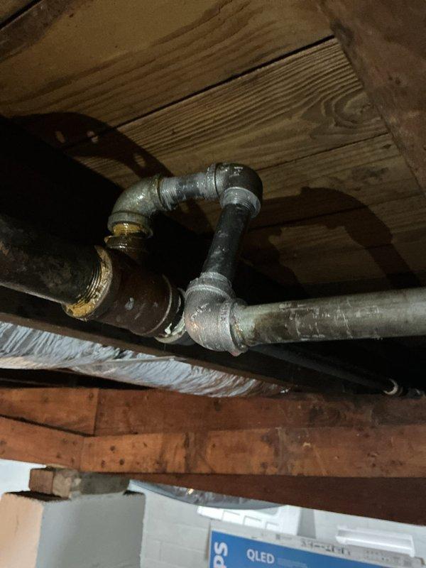 Responded to a reported gas leak with gas service shut off and leak source unknown, and inspected the gas piping at the water heater, including the black iron supply line, ball valve, and flexible appliance connectors, along with accessible gas piping in the basement floor joist area. Leak location was not identified on the initial visit, so a follow-up appointment is required to return and complete an air pressure test of the gas piping system to isolate the leak before restoring service.