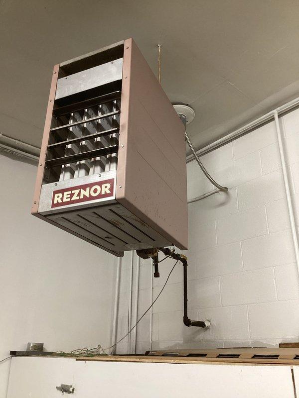 Inspected four suspended Reznor gas-fired unit heaters in a garage/shop space and documented existing conditions, including cabinet wear, black iron gas piping with surface rust, galvanized flue venting, threaded-rod hangers, and flexible electrical connections to ceiling junction boxes. Prepared an estimate to replace all four units, including gas line reconnection, flue and venting, electrical connections, and hanger support.