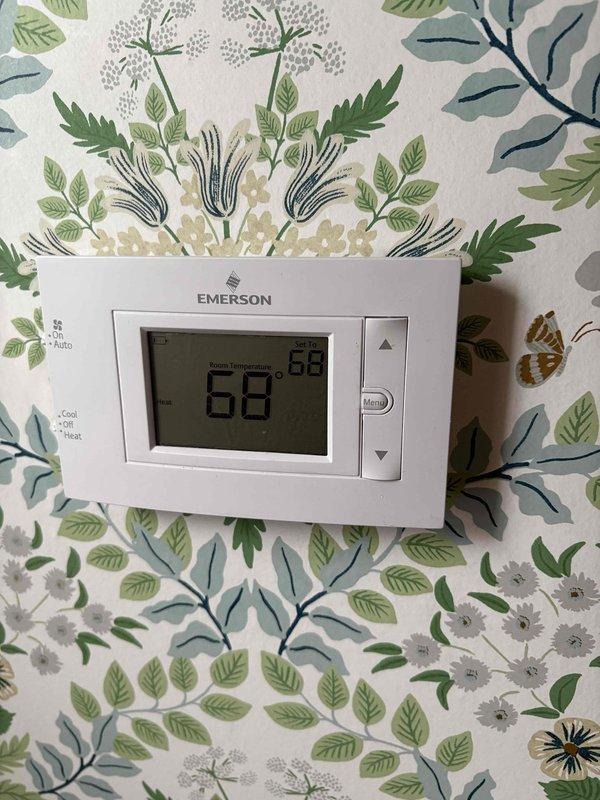 Conducted comprehensive site inspection to provide replacement quote for full HVAC system, including both furnace and AC components. Examined existing furnace installation in basement utility area with associated ductwork, humidifier, and ventilation components. Evaluated current thermostat (Emerson digital model displaying 68°F) to determine compatibility with potential new system.