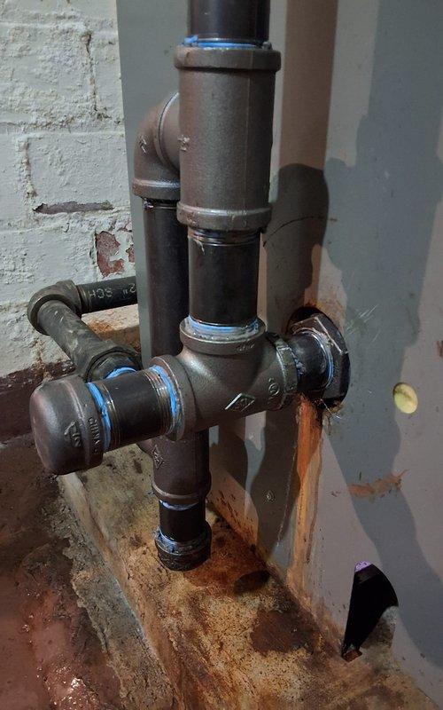 Replaced compromised nipple in steam boiler return line, addressing leakage evident by rust staining on floor. Retained and reconnected serviceable components of the original piping configuration, ensuring proper seal at all connection points using appropriate thread sealant.