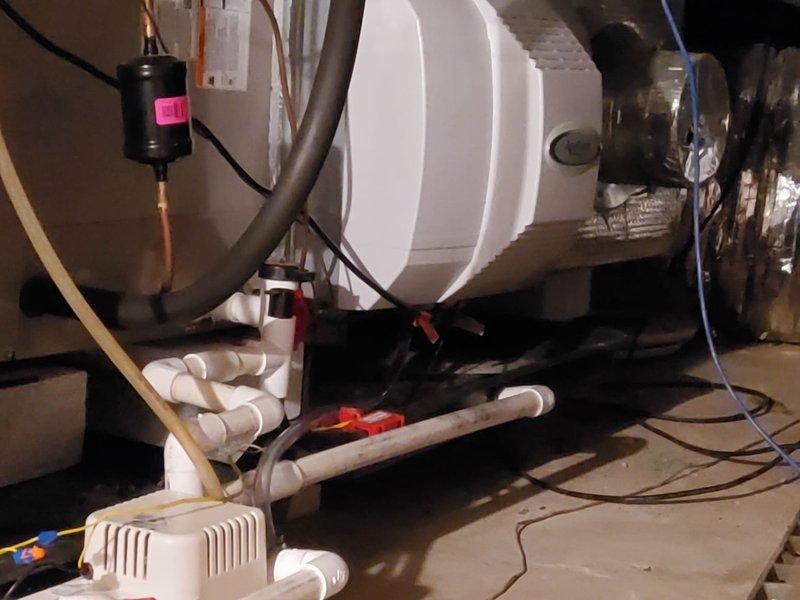 Inspected HVAC system with water leak originating from improperly installed humidifier without adequate drainage for emergency pan. Consulted with Dale Salo regarding proposed solution to replace damaged humidifier and modify drain pan configuration by raising it to connect with dedicated condensate pump. Noted that complete resolution of all drainage issues would require full equipment replacement.
