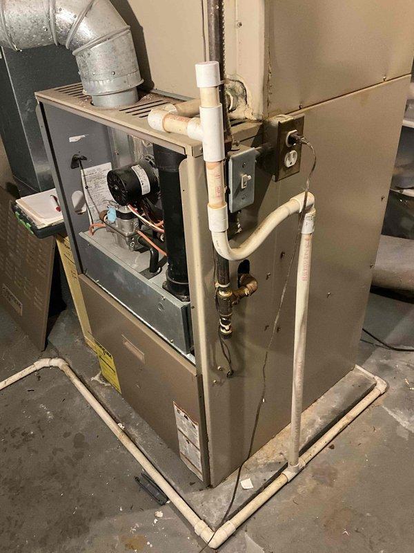 Performed diagnostic inspection on 20-year-old furnace with reported cracked heat exchanger and overheating issues. Visual assessment confirmed aging unit with deterioration and internal component wear. Provided customer with replacement options for 90,000-100,000 BTU two-stage furnace system with humidifier, and included additional quote for AC replacement though not immediately critical.