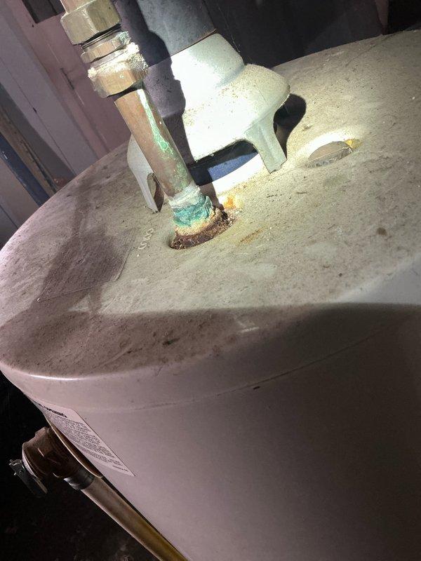 Performed tune-up maintenance on two furnace units in multi-family dwelling. Inspection revealed significant corrosion and mineral buildup at water heater pipe connections with visible green oxidation. Documented deterioration of fittings and potential leak points for future reference.