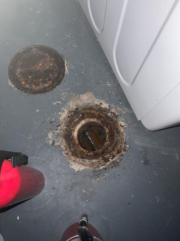 Responded to service call regarding sewer gas odor emanating from basement floor drain. Upon inspection, removed drain cover to reveal significant corrosion and deterioration around the drain opening. Cleaned drain pipe and surrounding area to eliminate the source of the offensive smell.