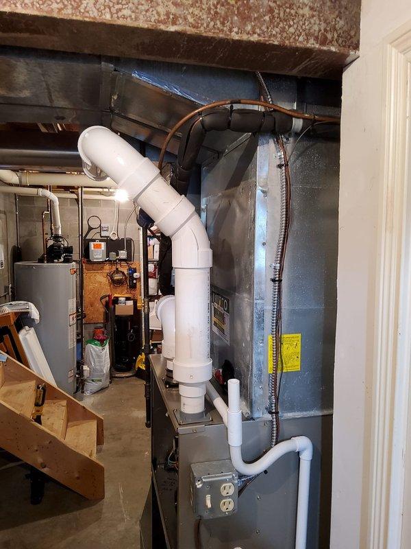 Successfully installed new furnace with integrated thermostat in residential utility area, including addition of 24" EZ Flex filter box beneath unit. Retained existing airflow base and 3" PVC single-pipe venting system for proper exhaust ventilation.