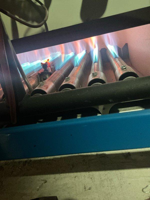 Performed scheduled boiler tune-up service on steam gas boiler system. Inspected heat exchanger which showed signs of aging with oxidation and mineral deposits. Verified proper burner operation with normal blue flame pattern indicating efficient combustion.