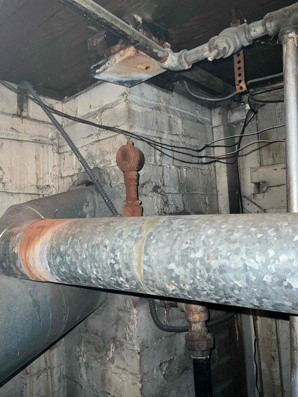 Performed scheduled boiler tune-up on 6-year-old system in basement utility area. Inspected aging plumbing infrastructure showing signs of corrosion on galvanized pipes and connections. Examined HVAC ductwork and associated copper piping for proper operation. System is functional but recommended monitoring of rusted components for future maintenance needs.