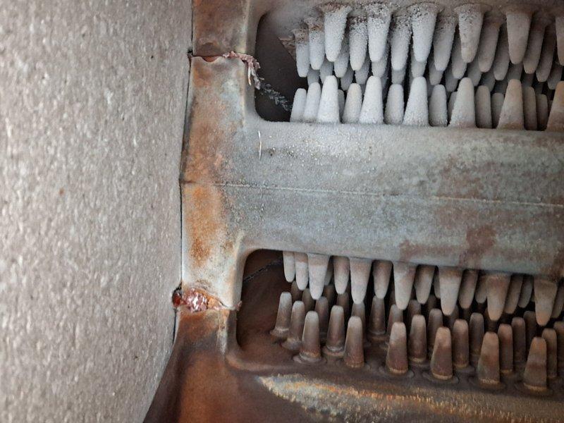 Performed scheduled Home Plan Heating Tune-Up and identified significant frost accumulation on evaporator coil along with advanced corrosion on heat exchanger components. System showing signs of restricted airflow and possible refrigerant flow issues evidenced by heavy ice formation on upper fins and brownish discoloration on lower sections.