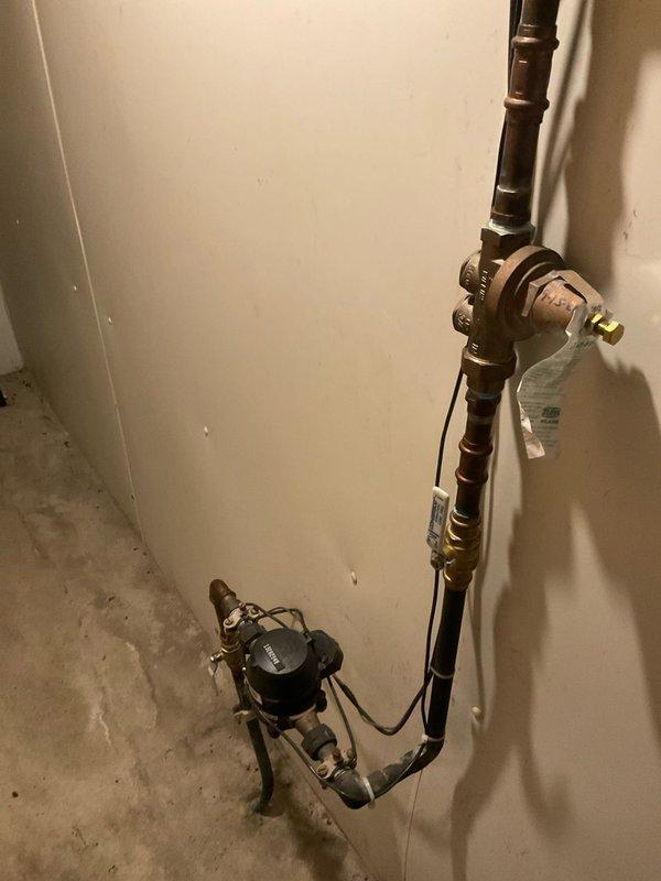 Performed diagnostic assessment on customer's tankless water heater system due to reported 2+ minute delay for hot water to reach kitchen sink. Inspected internal components of wall-mounted tankless unit and examined associated plumbing configuration. Identified circulation pump installed on return line that requires adjustment to improve hot water delivery time. Completed whole home plumbing assessment as part of service visit.