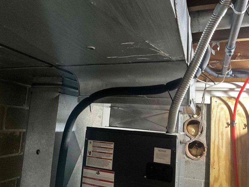 Conducted comprehensive inspection of existing HVAC system in utility room for potential humidifier installation. Evaluated current ductwork configuration, including spiral-wound flexible conduits and sheet metal components connected to the main furnace unit. Assessed available mounting locations and water supply access points for optimal humidifier placement.