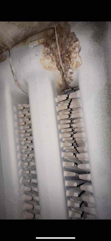 Performed scheduled boiler tune-up service. Discovered significant moisture damage and deterioration on heat exchanger components, with visible mold/rust accumulation at pipe connections. Inspected mechanical components including auger assembly which showed dirt buildup and wear.