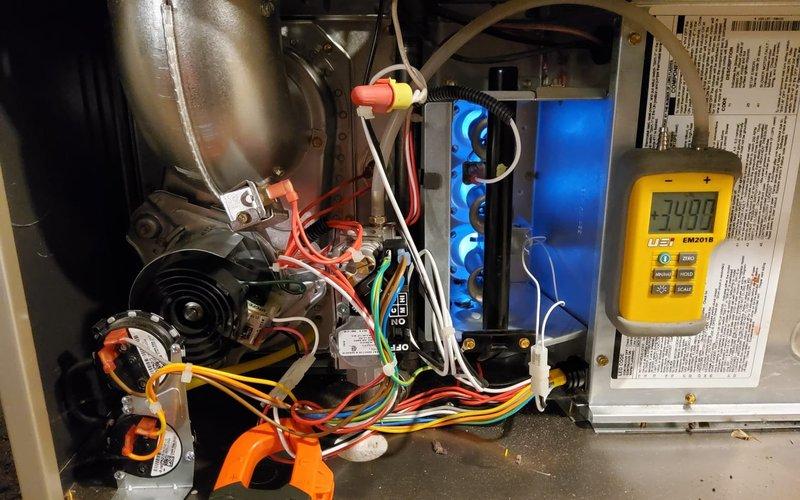 Performed comprehensive tune-up on customer's older furnace system. Conducted electrical testing with readings of 349 on control board components. Inspected heat exchanger, blower assembly, and wiring connections. Replaced thermostat batteries to resolve operational issues and provided information on AC cover options. Customer also has a newer furnace that requires filter replacement, which was noted for follow-up.