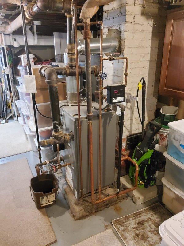 Responded to service call for 8-year-old boiler system with reported pipe leak. Inspection revealed significant water damage to ceiling with visible staining and deterioration directly below the boiler's supply lines. Located and repaired leaking pipe connection using friction tape after thoroughly documenting the damage with measurements and photographs for customer records.