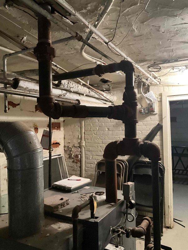 Conducted assessment of aging steam boiler system in basement mechanical room. Observed extensive network of copper piping with patina development and inspected pressure gauge readings on main unit. System appears to be functional but showing signs of age-related wear requiring potential maintenance.