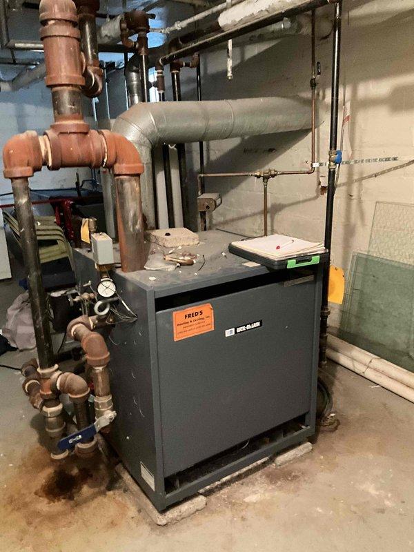 Conducted assessment of aging steam boiler system in basement mechanical room. Observed extensive network of copper piping with patina development and inspected pressure gauge readings on main unit. System appears to be functional but showing signs of age-related wear requiring potential maintenance.