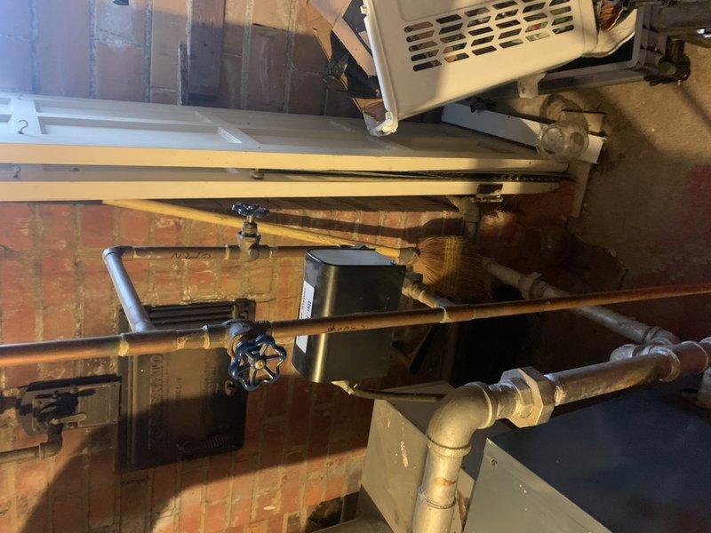 Performed diagnostic assessment on 20+ year old steam boiler system reported to be leaking. Inspected plumbing infrastructure in basement utility area, examining copper and galvanized piping, valve components, and control unit. Documented current condition with photos for comprehensive evaluation of repair options.