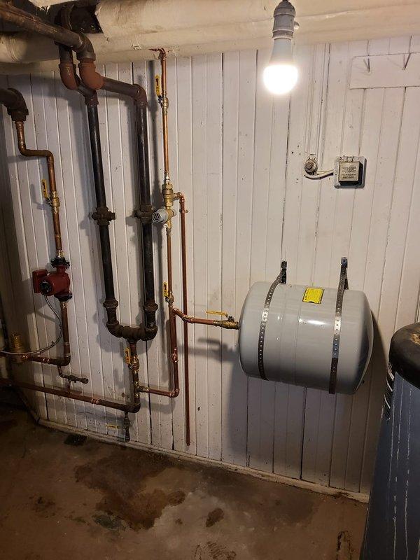 Completed installation of dual high-efficiency heat-only boilers with temporary connections to restore heating functionality. Removed two outdated storage tanks and installed a second hot water tank connected to the second boiler. Replaced failed expansion tanks, installed new backflow preventers, pressure reducing valves, thermostats, and vertical air eliminators. Temporary flue pipe connections were made with plans to replace them due to multiple leak points identified in the existing 1" copper system.