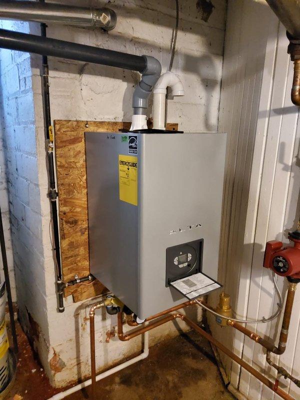 Completed installation of dual high-efficiency heat-only boilers with temporary connections to restore heating functionality. Removed two outdated storage tanks and installed a second hot water tank connected to the second boiler. Replaced failed expansion tanks, installed new backflow preventers, pressure reducing valves, thermostats, and vertical air eliminators. Temporary flue pipe connections were made with plans to replace them due to multiple leak points identified in the existing 1" copper system.