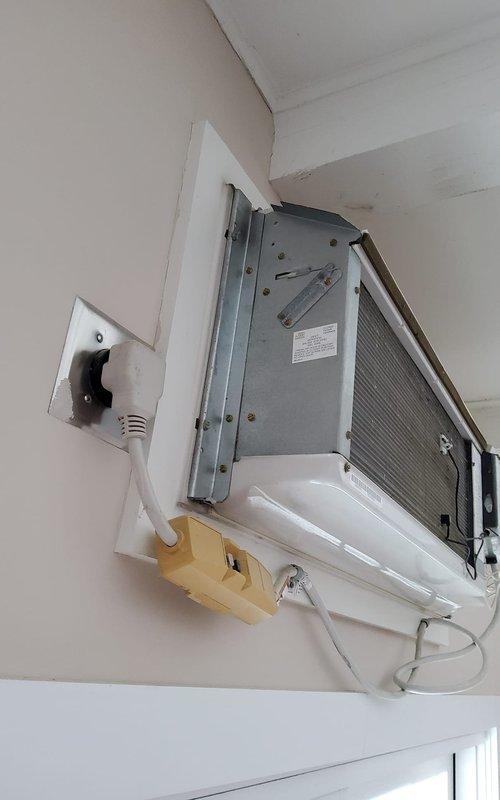 Responded to service call for non-operational furnace. Upon inspection, found wall-mounted mini-split AC system with possible electrical issues evidenced by discoloration around the outlet. Documented condition with photos for further assessment.