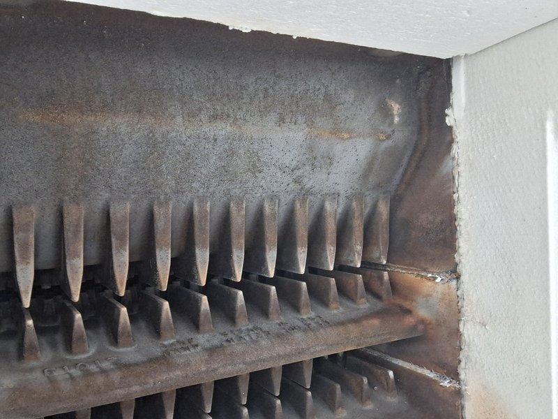 Performed annual heating system inspection and identified significant accumulation of dust, rust, and oxidation on heat exchanger fins. Documented extensive discoloration and wear on the metal components with visible evidence of moisture exposure. System requires thorough cleaning and assessment for proper heat transfer efficiency.