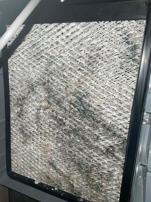 Performed standard furnace maintenance which revealed a severely clogged air filter with significant dust and debris accumulation, restricting proper airflow. Replaced the contaminated filter and verified system operation with temperature readings (63.6°F), restoring optimal system efficiency and preventing potential airflow restrictions.