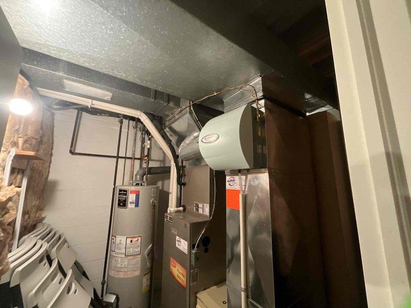 Performed comprehensive evaluation of aging HVAC system in residential basement mechanical room. Inspected existing furnace with attached humidifier, associated ductwork, and nearby water heater to provide customer with replacement estimate. Customer received information about financing options including 24-month no-interest payment plan.
