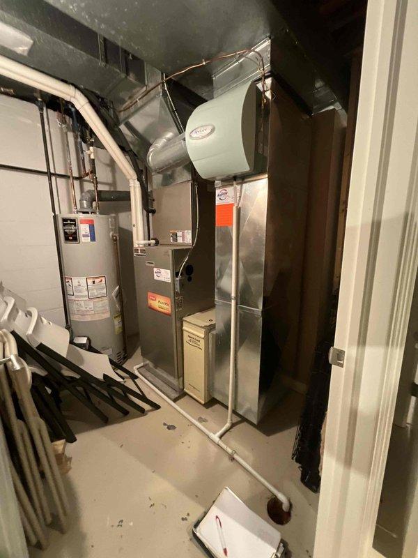 Performed comprehensive evaluation of aging HVAC system in residential basement mechanical room. Inspected existing furnace with attached humidifier, associated ductwork, and nearby water heater to provide customer with replacement estimate. Customer received information about financing options including 24-month no-interest payment plan.