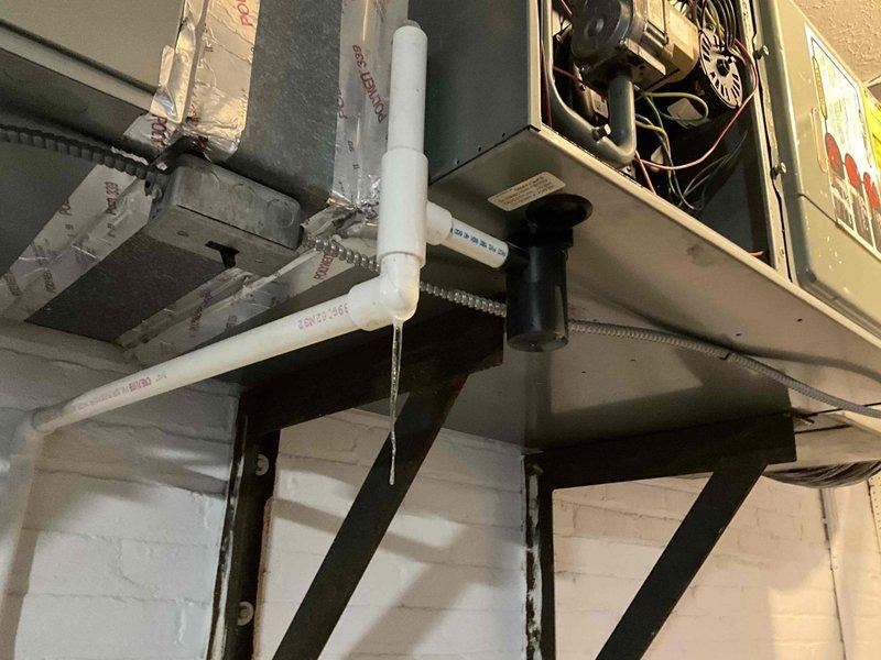 Responded to no-heat service call for a 20-year-old furnace system. Upon inspection, discovered deteriorated PVC condensate drainage with visible leakage and wall penetration damage. Recommended complete system replacement due to age and condition of equipment, with attention to proper drainage installation and sealing to prevent future moisture issues.