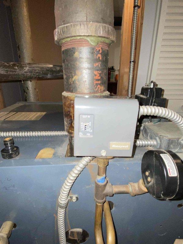 Performed scheduled maintenance on steam boiler system. Inspected circulation pump assembly mounted on wooden backboard and examined Honeywell control box connections. Checked valve operation and inspected copper piping configuration for proper functionality and signs of corrosion.