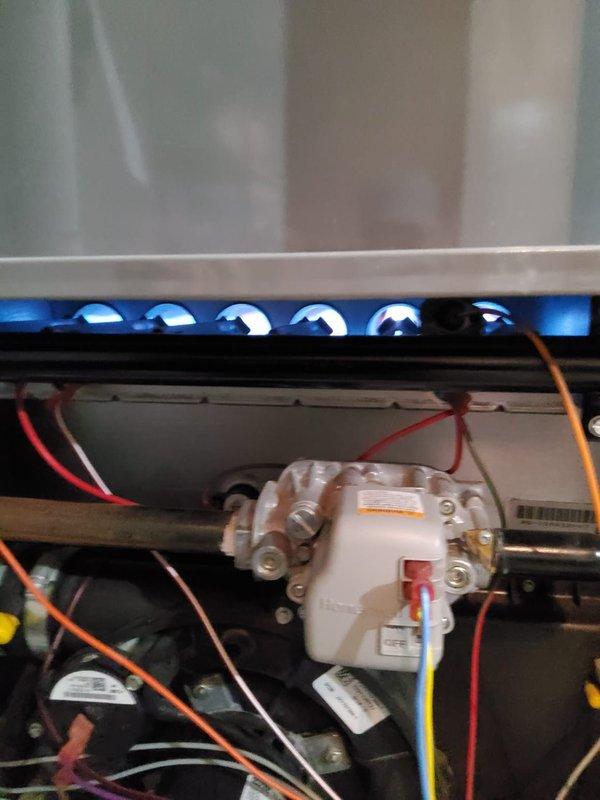 Performed scheduled maintenance on customer's heating system. Inspected blower wheel assembly and motor components, checking electrical connections and verifying proper operation of ignition system (blue flame indicators observed). System was returned to service in good working condition.