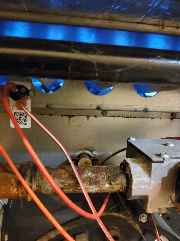 Responded to service call for 10-year-old furnace with loud fan noise. Inspection revealed severe corrosion and rust on the heat exchanger pipe while system was operational. Determined heat exchanger failure requires complete replacement due to safety concerns with potential carbon monoxide leakage.