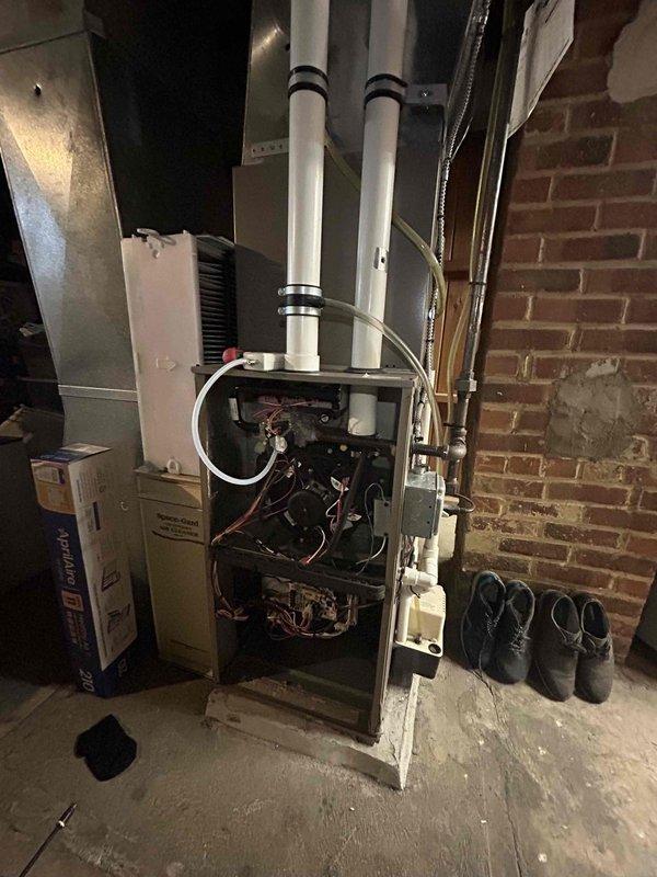Performed scheduled heating tune-up on residential furnace. Conducted electrical testing with multimeter showing 27.4 amps and verified proper operation of the system. Inspected internal components with front panel removed including wiring, circuit boards, and exhaust/intake piping.