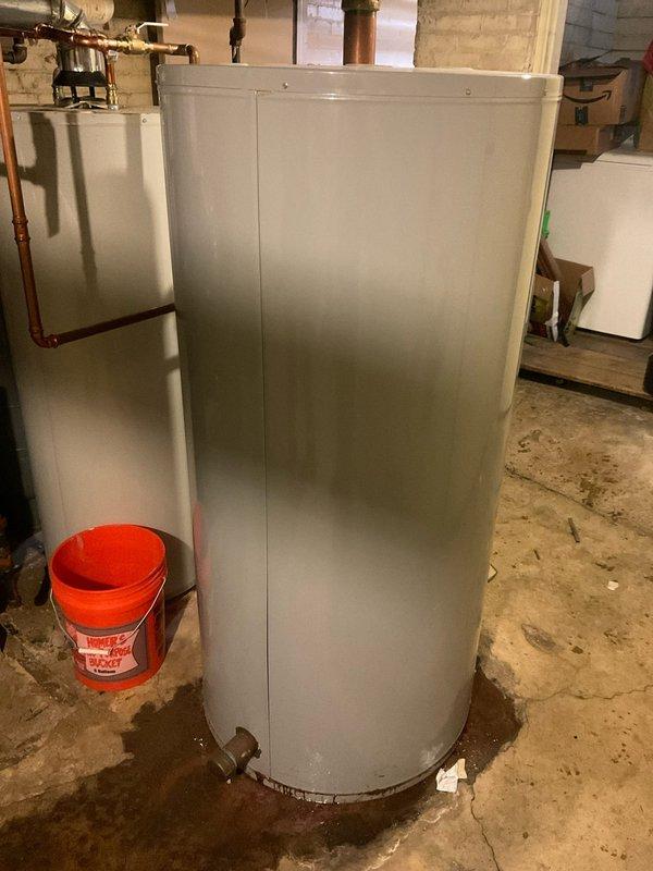 Responded to customer call regarding a small leak from water heater. Upon inspection, identified minor seepage at the drain valve connection of an A.O. Smith tank water heater. Placed catch bucket to contain dripping while performing repair. Tightened valve connection and verified leak was successfully resolved. System now operating normally with no visible moisture.