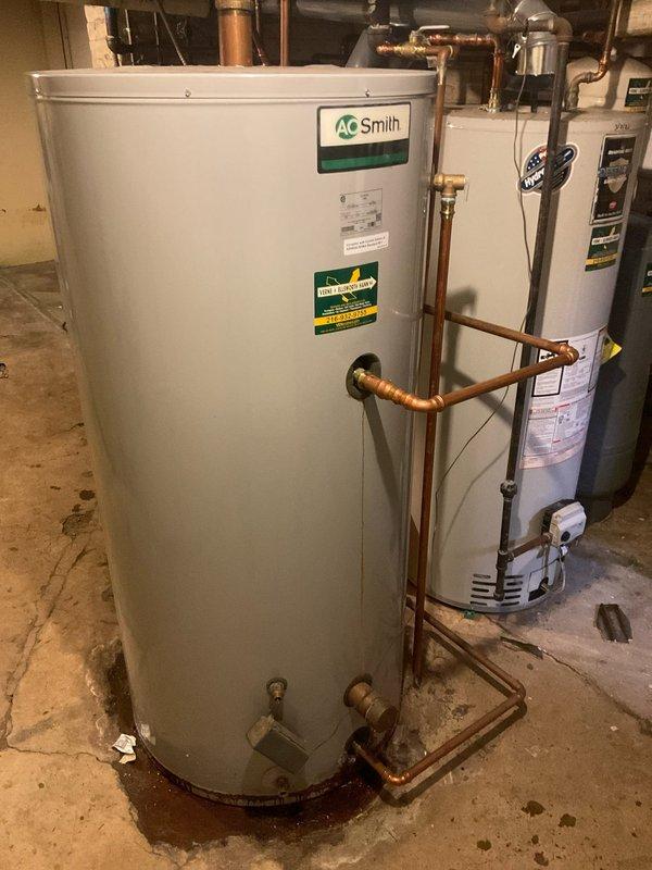 Responded to customer call regarding a small leak from water heater. Upon inspection, identified minor seepage at the drain valve connection of an A.O. Smith tank water heater. Placed catch bucket to contain dripping while performing repair. Tightened valve connection and verified leak was successfully resolved. System now operating normally with no visible moisture.