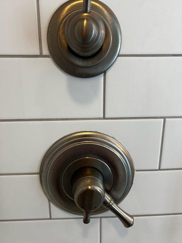 Replaced defective hot water handle mechanism on Delta shower fixture in 150-year-old home. Restored proper functionality to shower control system. All components now operating correctly with no leaks observed.